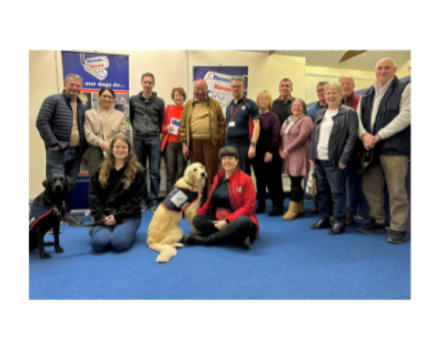 Group shot of some of our supporters with two assistance dogs sat at the front