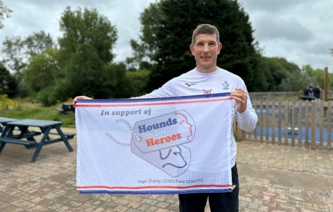 Paralympian Gregg Stevenson with Hounds for Heroes flag 